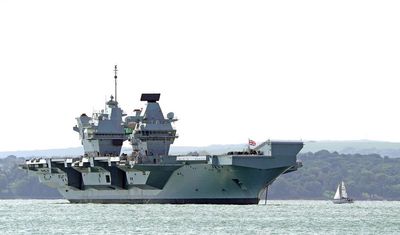 Engineers inspect damaged propeller shaft of broken down aircraft carrier