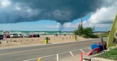Huge twister waterspout forms over Lake Huron as Canadian beachgoers look on in awe