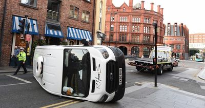 Delivery driver pulled from van by stranger after it flips onto the side in city centre