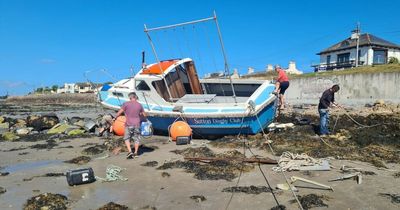 Stormy weather sees club's prized boat tossed onto beach in Dublin
