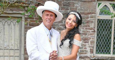 Happy Mondays' Bez looks dapper in a white suit and 'pimp hat' as ties the knot