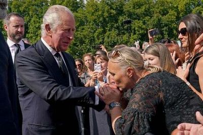 Kisses for the King: Charles greets hundreds of well-wishers outside Buckingham Palace