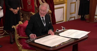 Charles grimaces as pen tray gets in the way as he signs declaration on becoming King