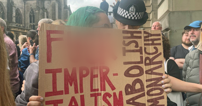 Protester with crude sign taken away by police at proclamation