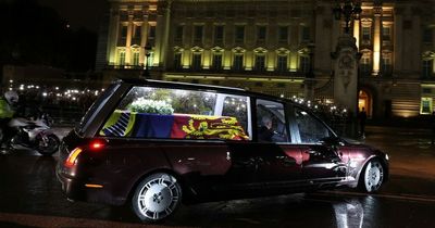 Princes William and Harry stand together to greet Queen's coffin at Buckingham Palace