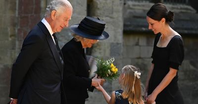 Touching moment little girl grabbed Queen Consort's hand after giving her a posy