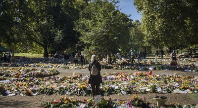 A London park blooms with flowers, stuffed animals and handwritten notes to the queen