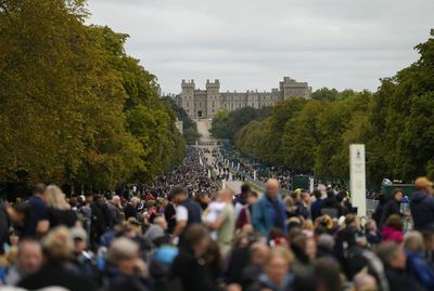 Windsor crowds sing national anthem as they await arrival of Queen’s coffin