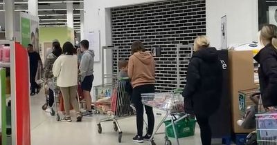 Asda shoppers queue around entire Manchester store with 'shelves bare' as it reopens after Queen's funeral