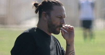 Kevin Federline cuts glum figure as he puffs on cigarette at daughter's football game