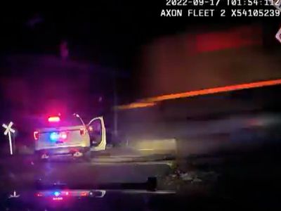 Harrowing moment train hits a parked Colorado police car with suspect inside