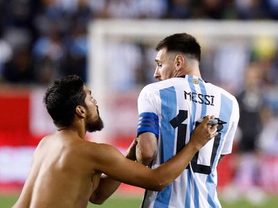 Lionel Messi nearly knocked over as security guards tackle pitch invader during Argentina match