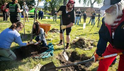 Volunteers plant trees at Shriners hospital to create buffer from passenger, freight trains
