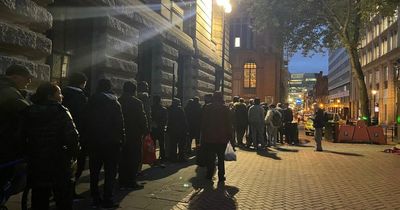 Hungry people queue for food in a side street close to the Conservative Party conference