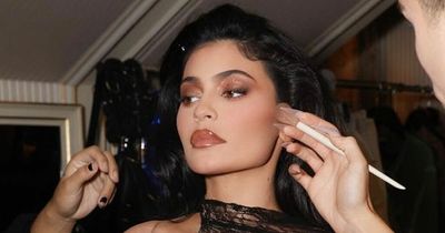Kylie Jenner wears tiny black bikini as she cuddles up to son for rare snap of the tot