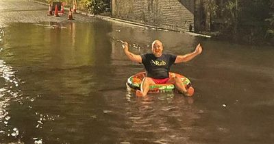 Dad sick of floods on road near his house grabs rubber ring and swims in giant puddle