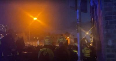 Police scuffle with balaclava-clad Rangers fans before Liverpool FC match