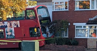 Double decker bus smashes into BMW and house after driver dies of 'medical episode'