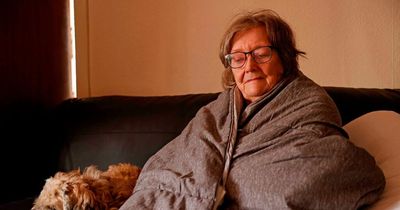 Woman without central heating left sleeping on sofa next to fire