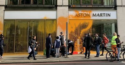 Eco protesters douse bright orange spray paint over Aston Martin showroom in London