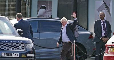 Boris Johnson waves at press as he touches down in UK amid leadership speculation