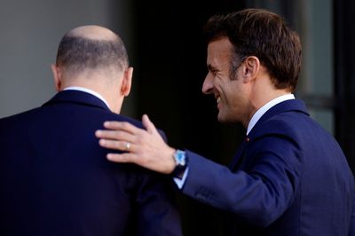Macron, Scholz plaster over differences with smiles and a handshake