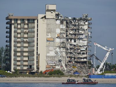 A Miami building is evacuated near the site of the deadly Surfside condo collapse