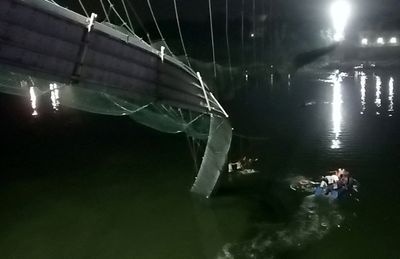 More than 80 killed in India as bridge packed with holiday sightseers collapses