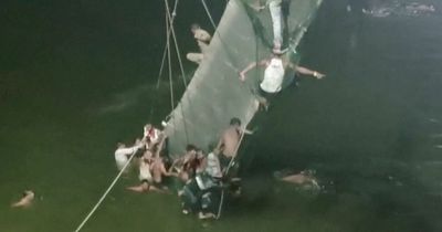 Sixty killed as pedestrian bridge collapse in India plunges hundreds into river
