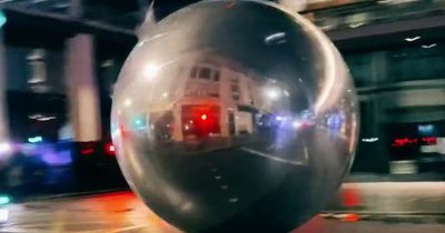 Giant Christmas baubles roll through Tottenham Court Road causing traffic chaos