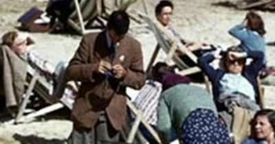 Bizarre 1940's beach photo proves 'time travel is real' after mystery man is spotted with mobile phone