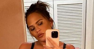 Chrissy Teigen shows off her blossoming baby bump as she poses in underwear