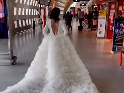 Bride seen sprinting through Paris airport in enormous wedding dress