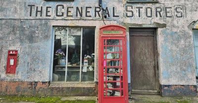 Inside empty vintage shop with stuff still on its shelves and a red telephone box on its doorstep