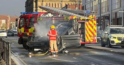 Two people rushed to hospital after Audi overturns in Oldham town centre crash