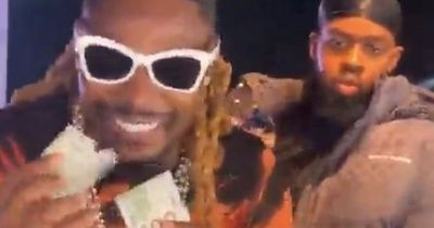 Singer hands fans 100 dollar bills as he is 'booed for turning up late'
