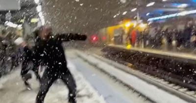 Massive snowball fight erupts at London train station as delayed commuters pass the time