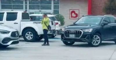 Driver fumes as shopper stands in parking space and refuses to move