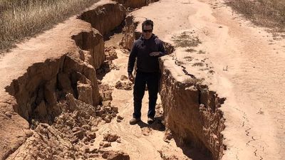 Regional Victorian road opens up like a canyon after floodwaters cause 1.4-metre trench down centre