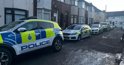 Police surround street as woman's body found in home