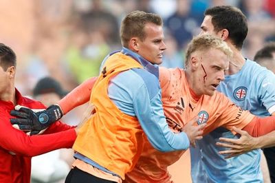 Melbourne A-League derby abandoned after goalkeeper left bloodied after violent pitch invasion