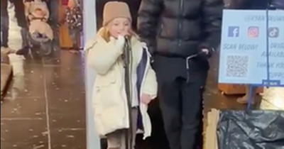 Adorable moment Scots schoolgirl belts out songs to Christmas crowds after getting busker's mic