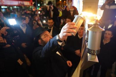 Group subjected to antisemitic attack in London return to scene to celebrate Hanukkah