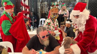 Sydneysiders celebrate Christmas at the beach as iconic lunch for homeless returns to Kings Cross