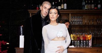 Kourtney Kardashian cuddles up to Travis Barker with a hand on her stomach in cosy pics