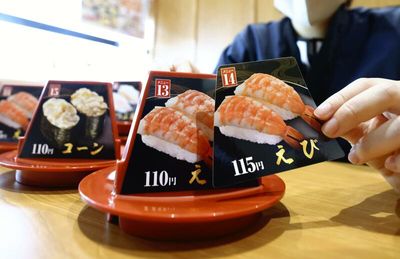 Conveyor-belt sushi chains diverge over pricing