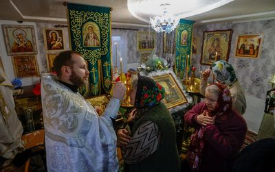 People in occupied Ukraine town mark Christmas Eve in home after church is shelled