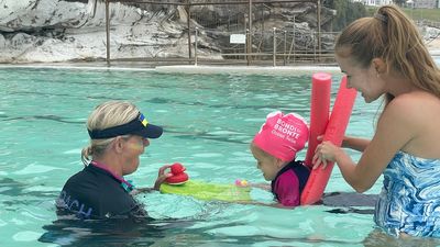 Ukrainian refugees learn how to swim in Australian beach conditions