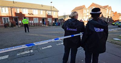 Schoolchildren walk past open door of house where woman was stabbed