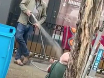 Gallery owner arrested after being filmed hosing homeless woman